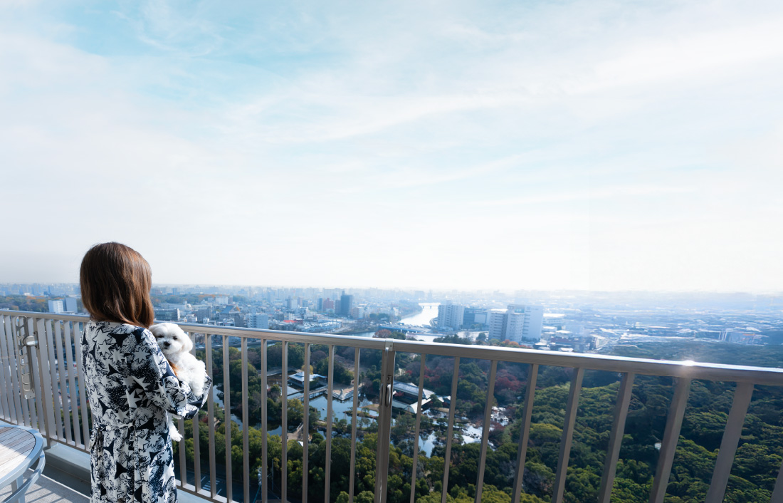 マンションのベランダから外を見渡すオーナー様